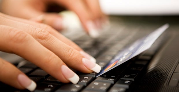 Femme saisissant sa carte bancaire en ligne