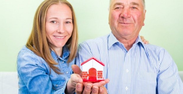  Un couple tenant une maison en miniature 