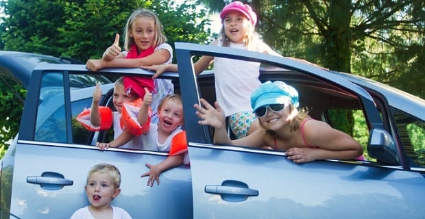 Des enfants à la porte de leur véhicule de famille 