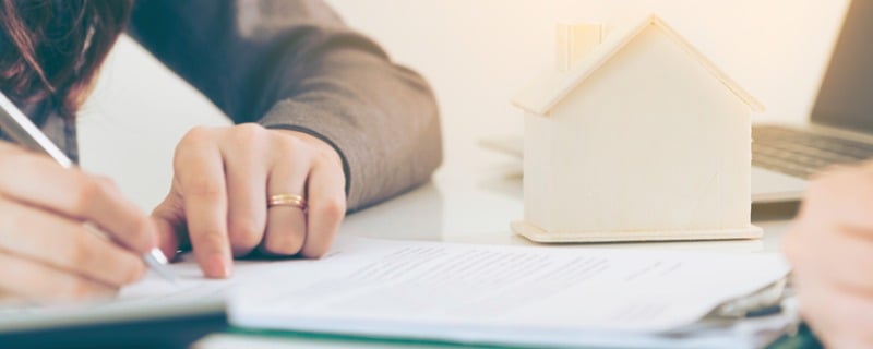 Signature d'un contrat avec modèle réduit d'une maison à coté du contrat
