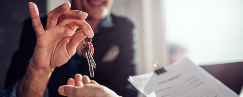 Agent immobilier donnant les clefs à son client.