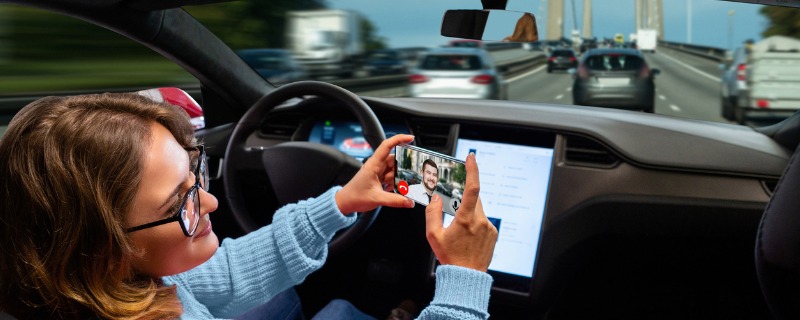 Femme prenant une video dans une voiture autonome.
