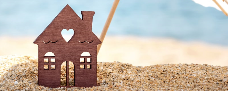 Maison et parapluie miniatures sur la plage