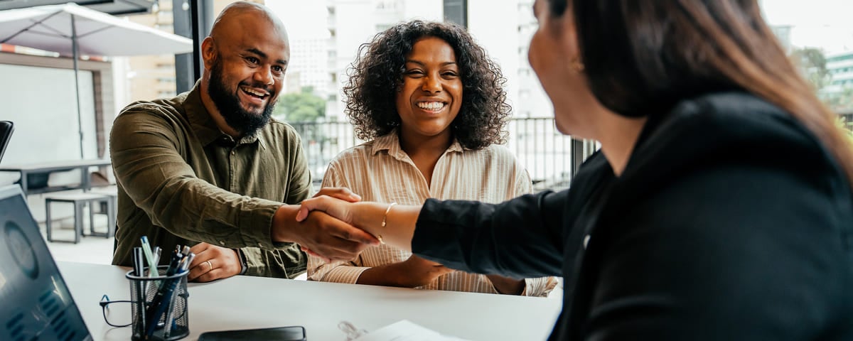Couple concluant un contrat immobilier avec un agent immobilier