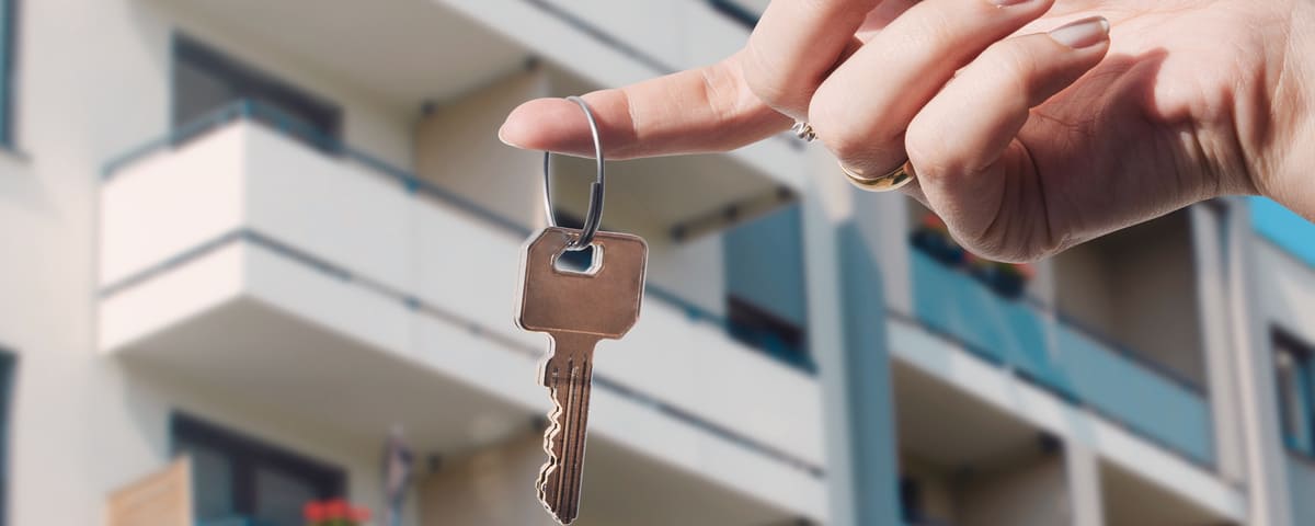 Agent immobilier retenant des clefs au nouvel appartement