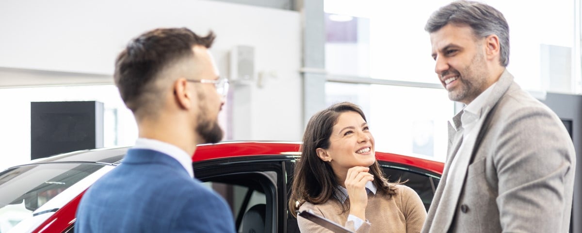  Couple discutant avec un vendeur de voiture