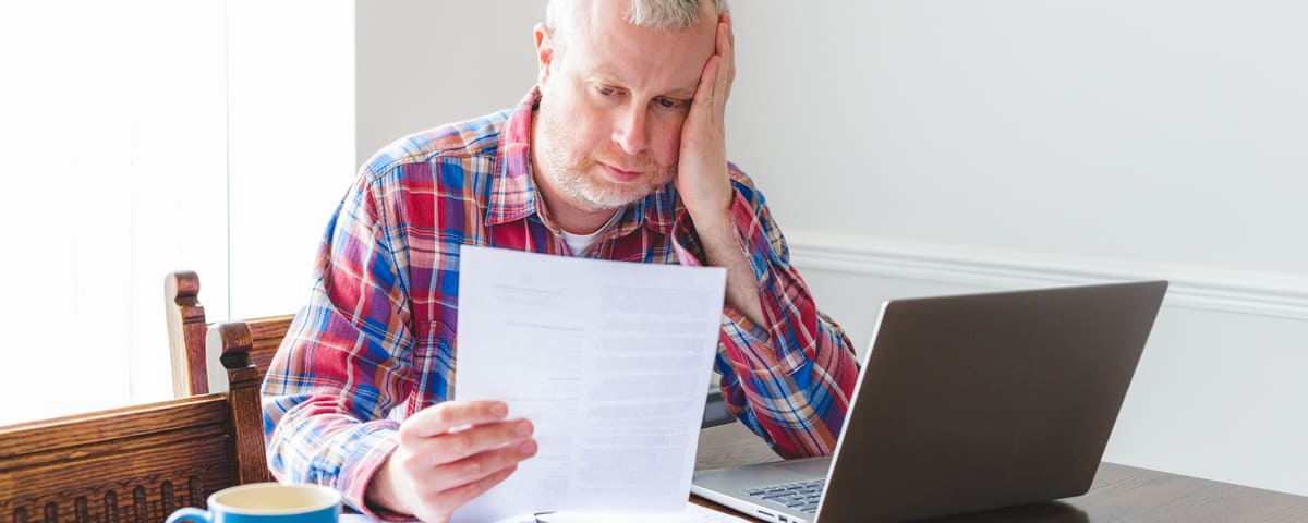 Un homme  visiblement stressé, symbolisant la charge du surendettement